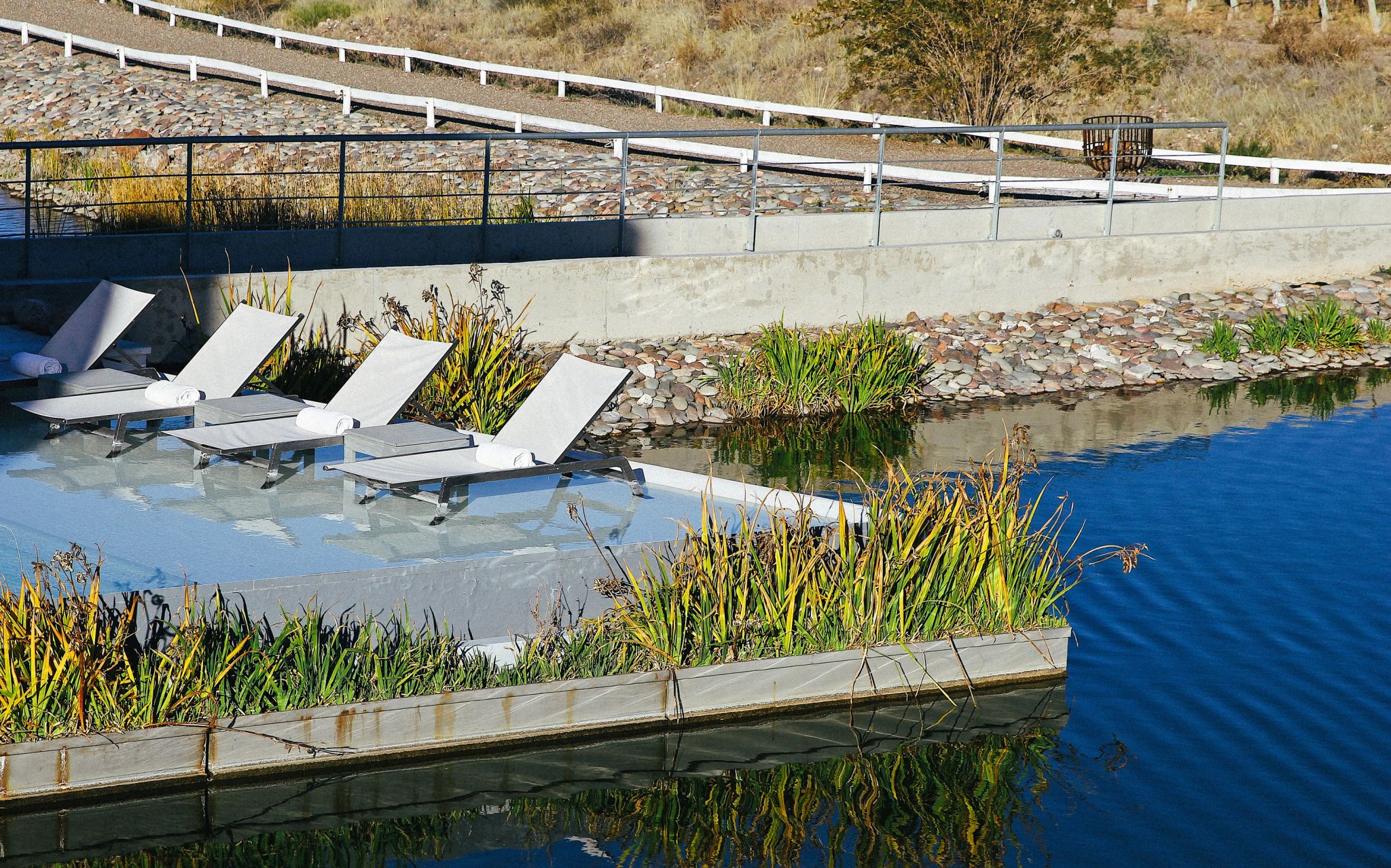 piscina e área de relaxamento integradas ao paisagismo no casa de uco