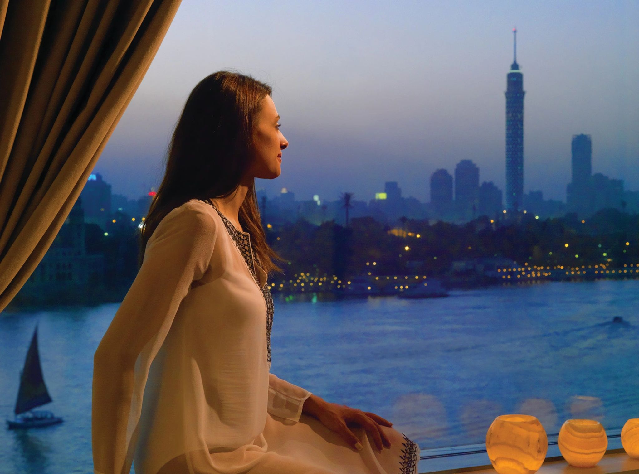 Vista Panorâmica mulher apreciando o skyline do cairo – suite de luxo - vista para o nilo