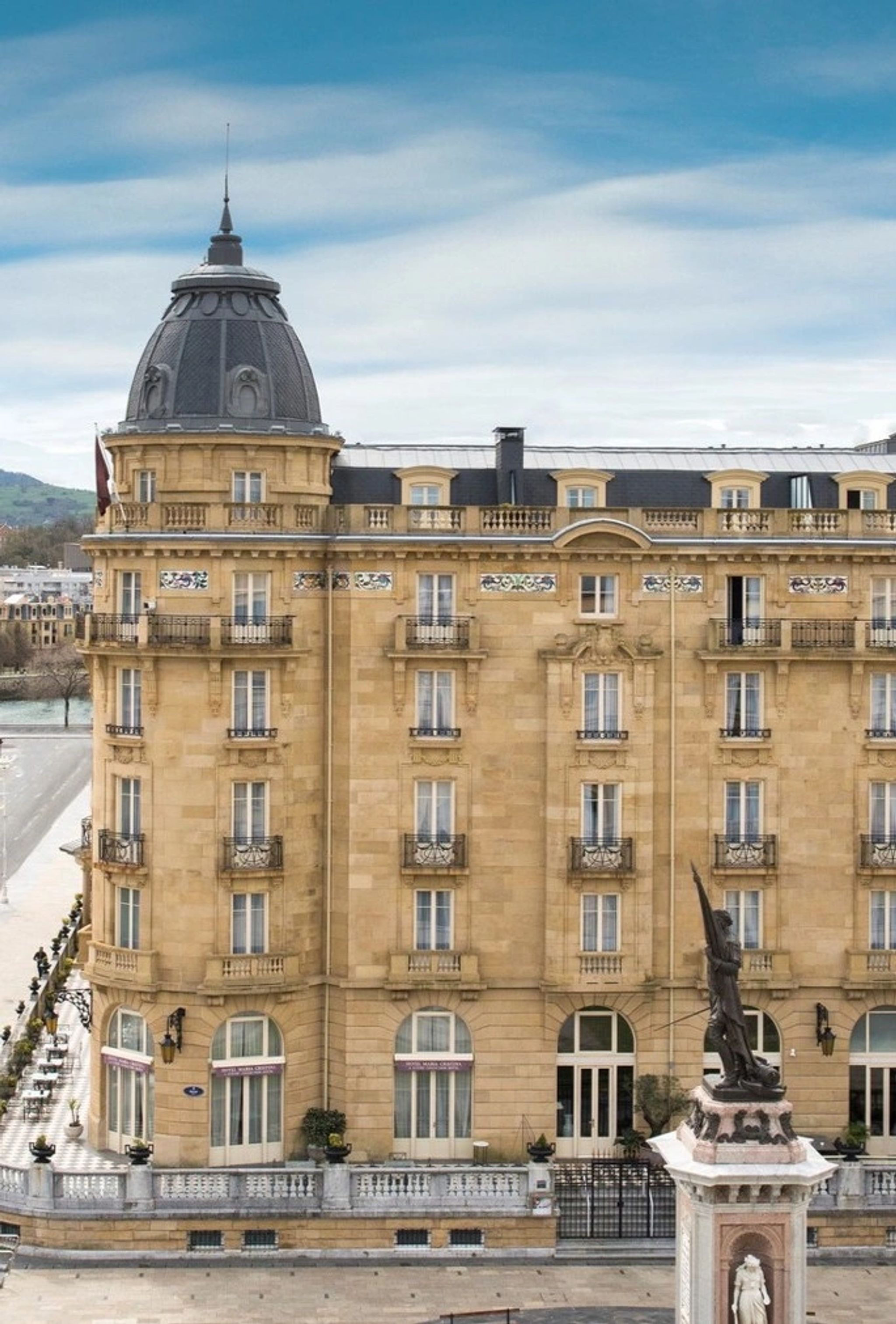 fachada de hotel classico - estatua de bronze - predio de pedra bege
