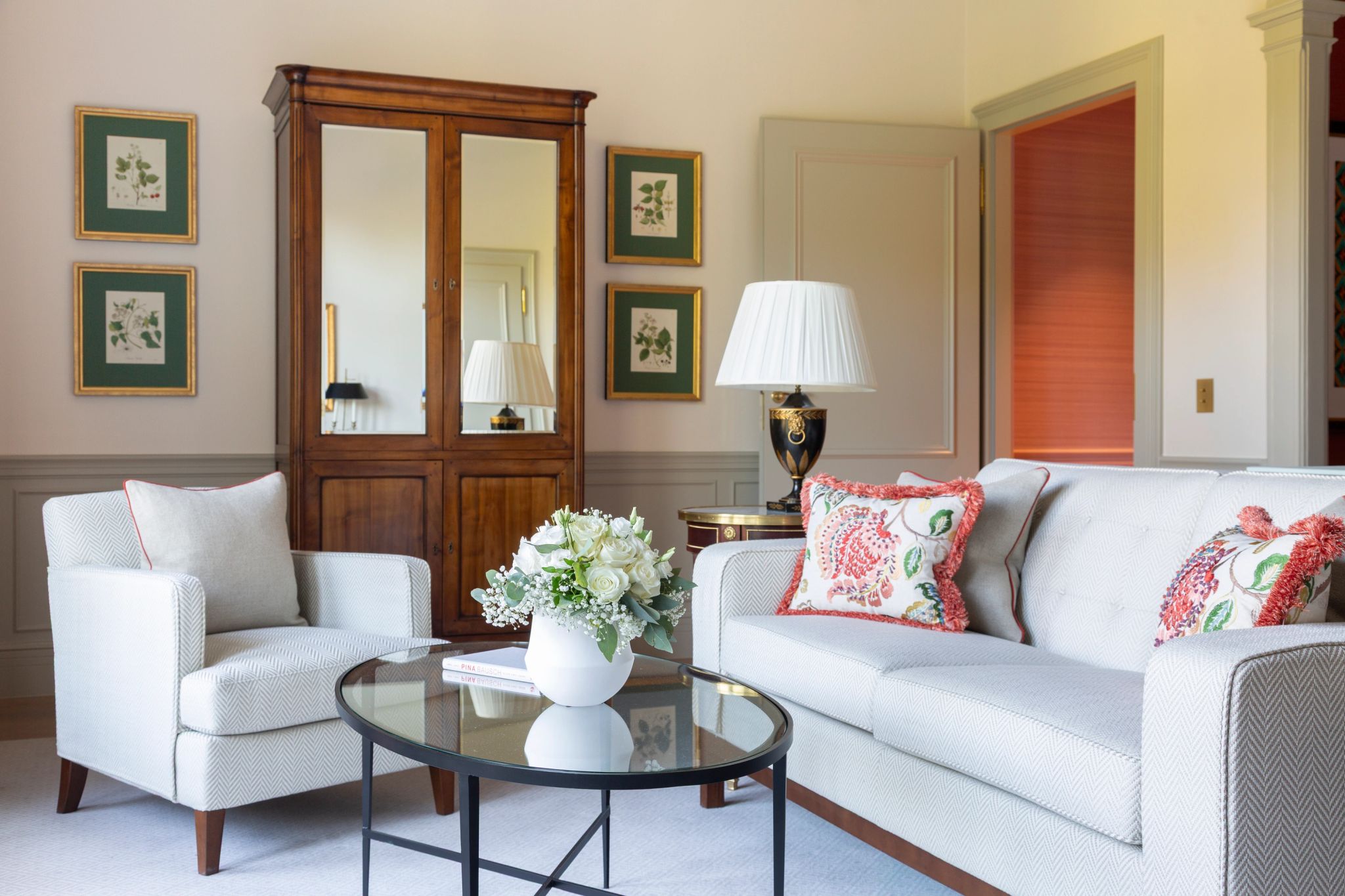 sala com sofa claro, mesa de centro e arranjo floral