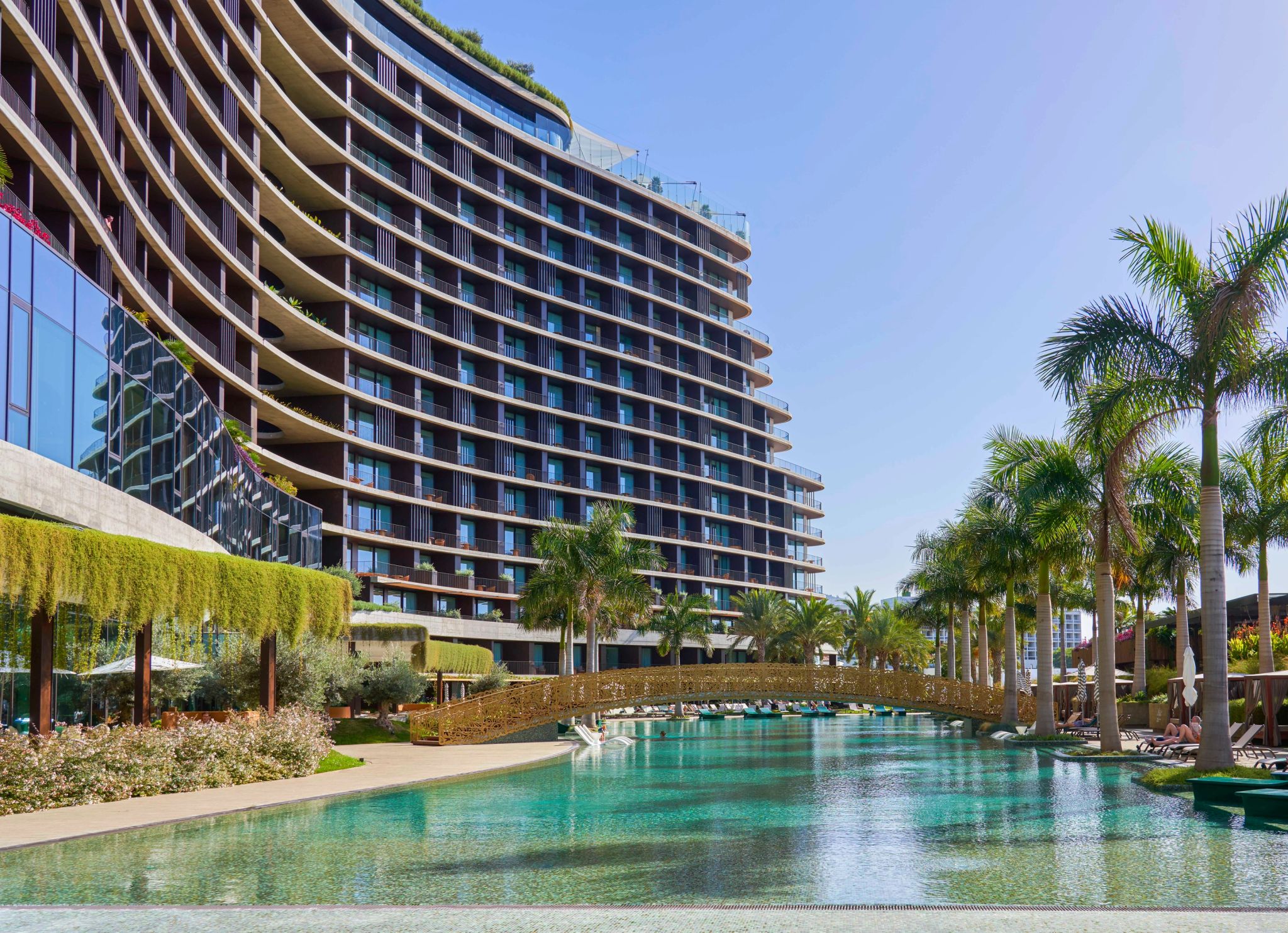 Piscina hotel cinco estrelas com piscina exterior rodeada por palmeiras