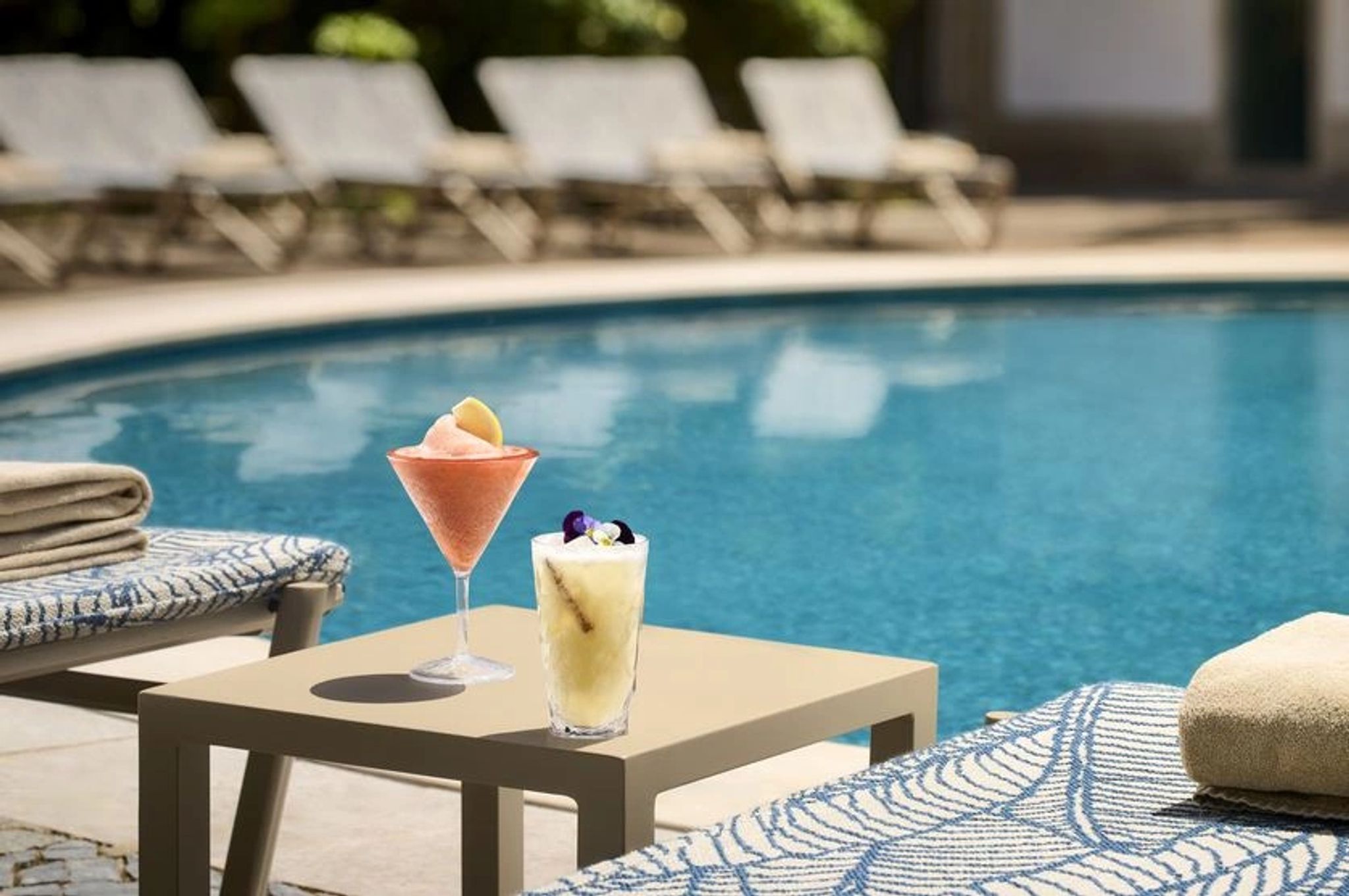 Piscina ao Ar Livre piscina iluminada com coquetel sobre mesa em area de lazer elegante no hotel anantara em lisboa
