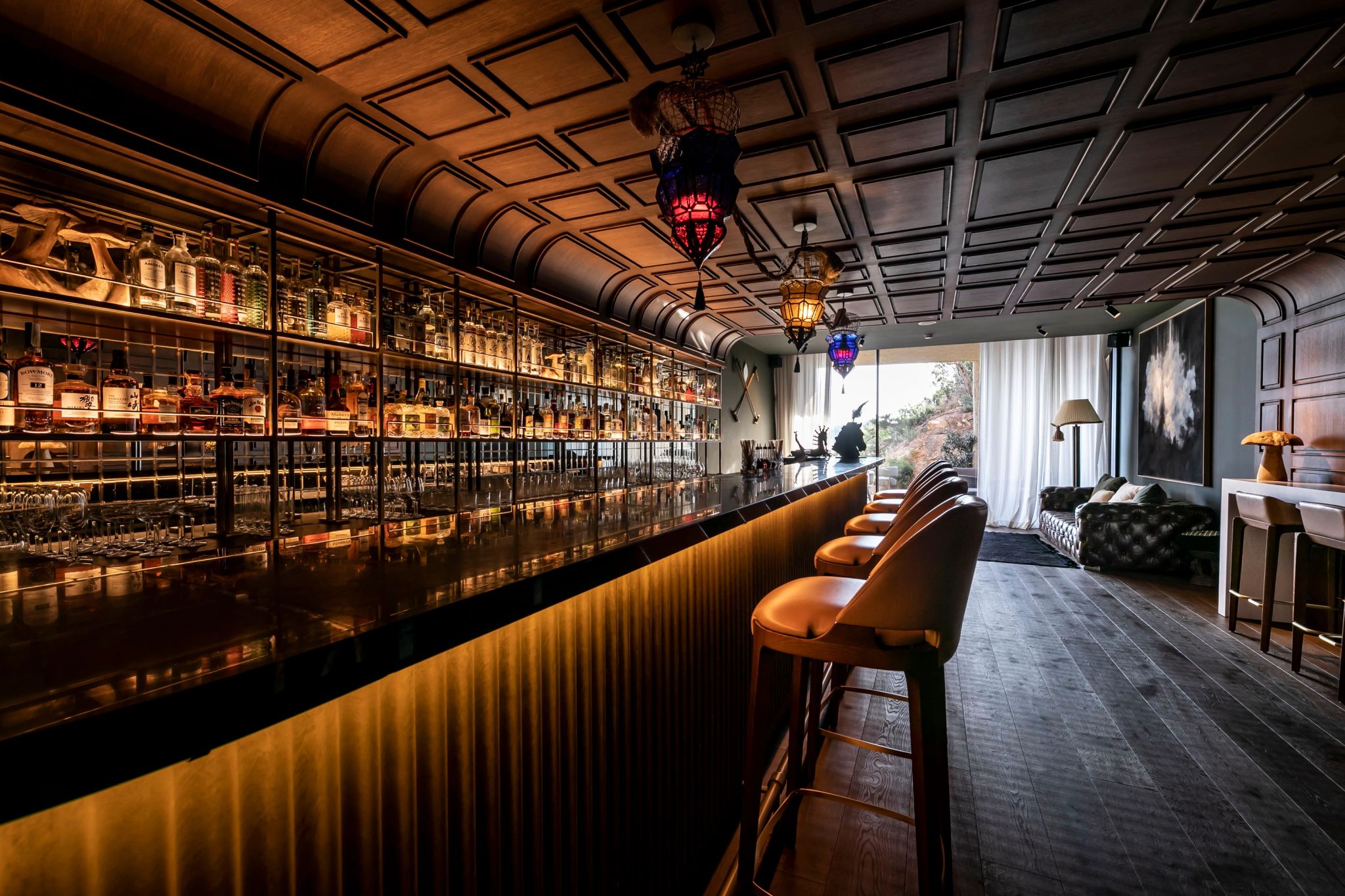 Bar Secreto balcao de madeira escura - garrafas iluminadas - luz baixa intima