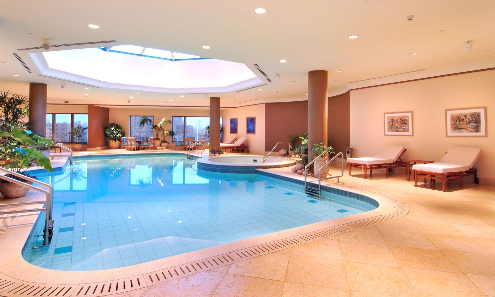 piscina interna com teto oval iluminado e espaco relaxante