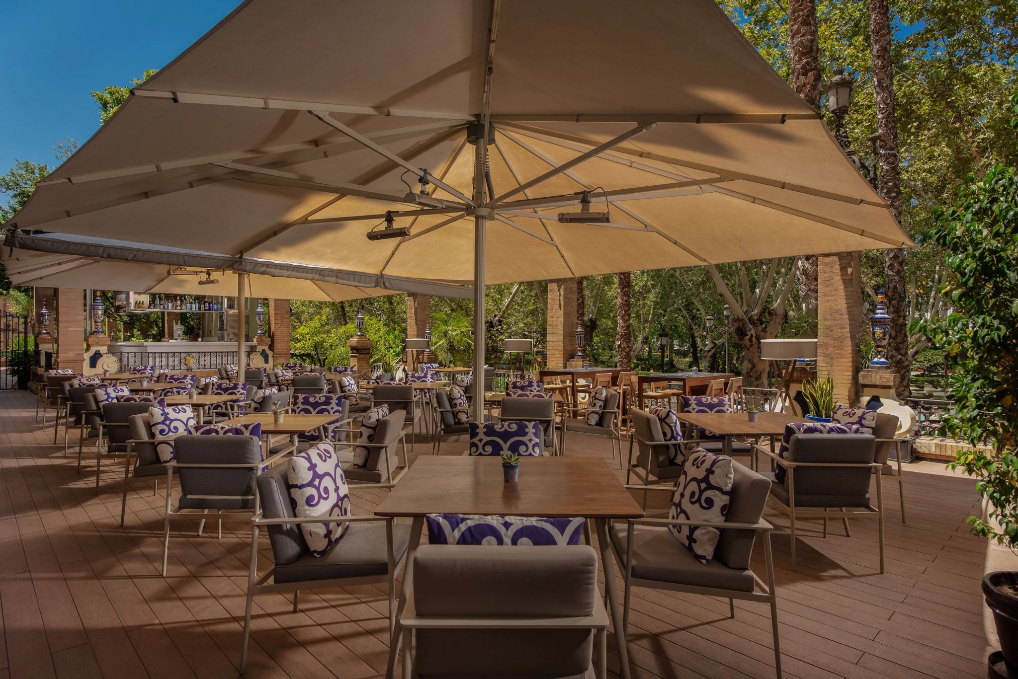 mesas sob guarda sois brancos em area externa de hotel de luxo