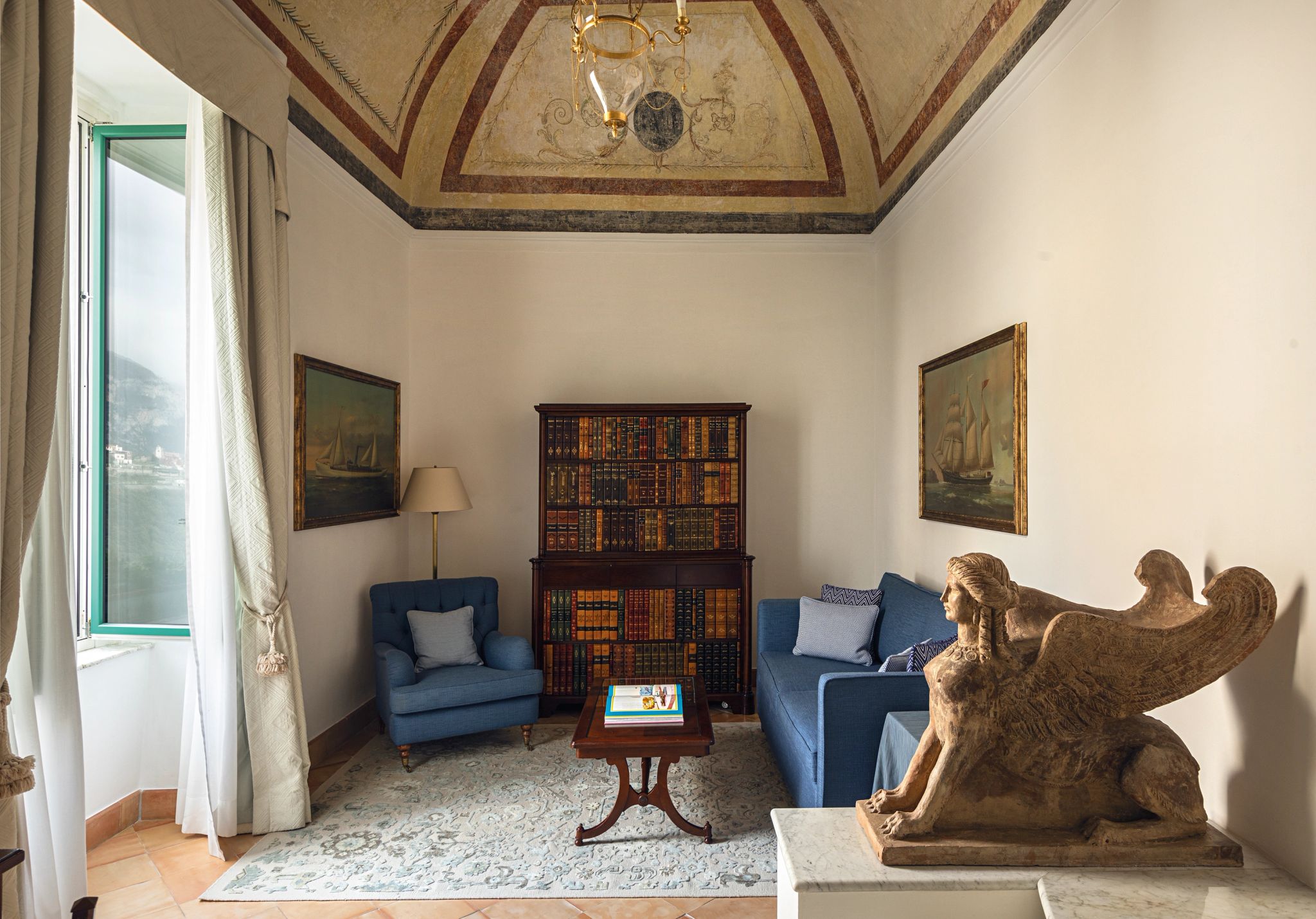 suite com sala - sala de estar - suite classica - biblioteca - estante de livros - esculturas classicas