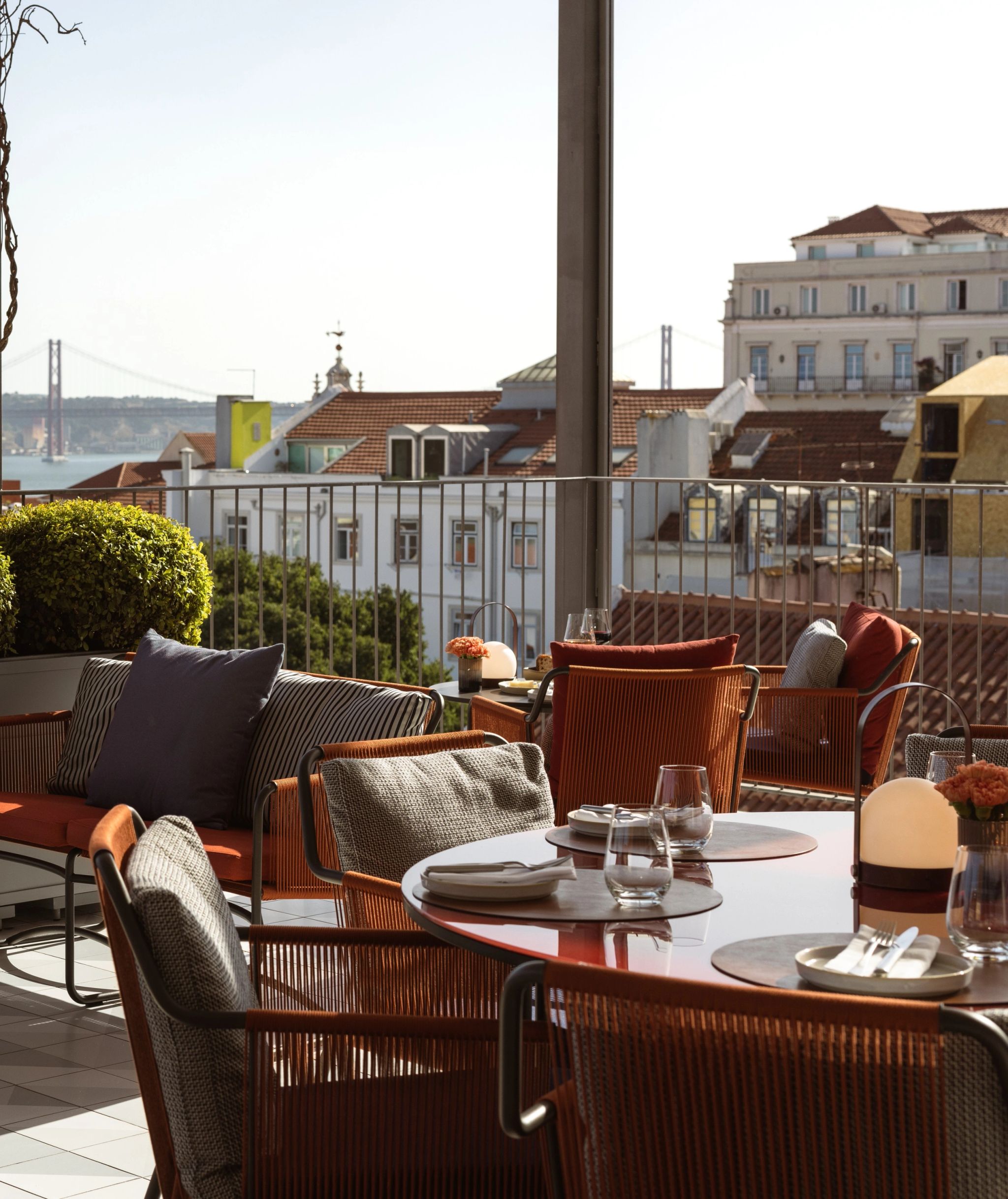mesa de jantar no rooftop - poltronas laranjas - vista da ponte e cidade