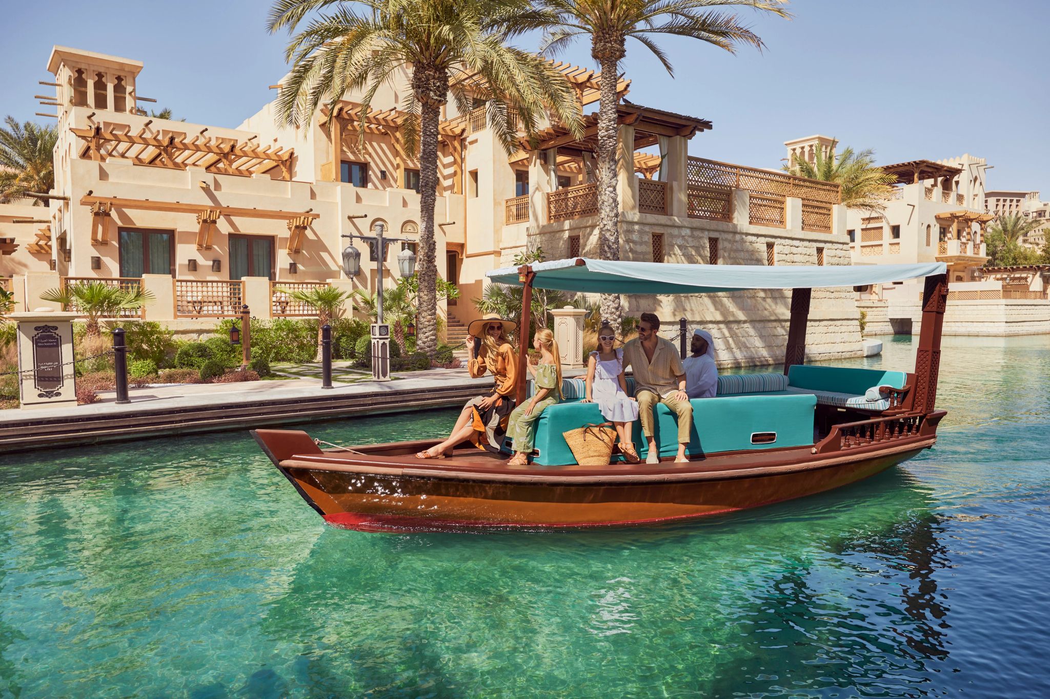 família aproveitando passeio de abra nos canais do resort em dubai – barco de madeira